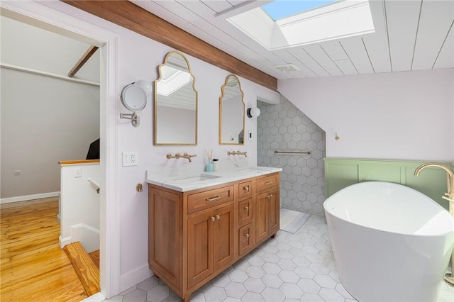 3 Hidden St, Providence, RI 02906 - full bath with a skylight, a freestanding tub, double vanity, tile patterned floors, and lofted ceiling