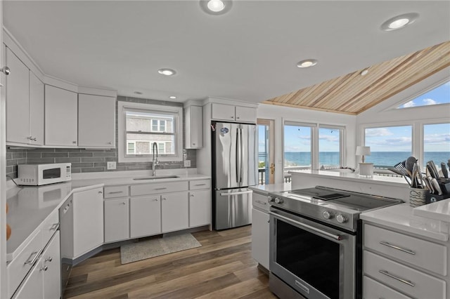 419 Atlantic Ave, Westerly, RI 02891 - kitchen with stainless steel appliances, a sink, wood finished floors, light countertops, and backsplash