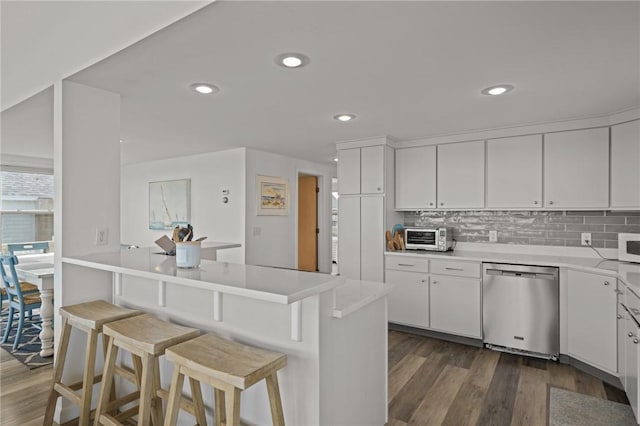 419 Atlantic Ave, Westerly, RI 02891 - kitchen with dishwasher, a kitchen breakfast bar, dark wood-style flooring, white cabinetry, and tasteful backsplash