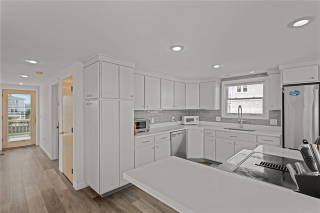 419 Atlantic Ave, Westerly, RI 02891 - kitchen with appliances with stainless steel finishes, a sink, white cabinetry, decorative backsplash, and recessed lighting
