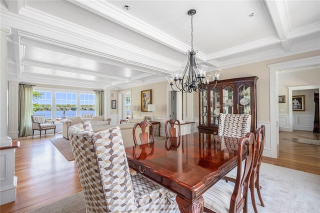 136 Adams Point Rd, Barrington, RI 02806 - dining space with light wood-style flooring, crown molding, beamed ceiling, a chandelier, and decorative columns