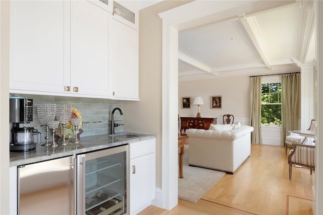 136 Adams Point Rd, Barrington, RI 02806 - indoor wet bar featuring light wood finished floors, wine cooler, tasteful backsplash, coffered ceiling, and beamed ceiling