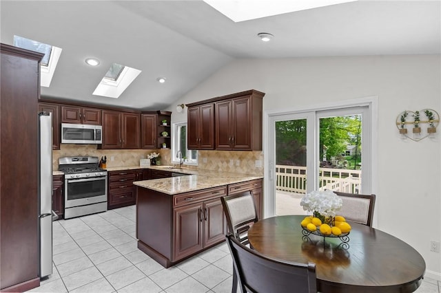 23 Watercress Ct, Coventry, RI 02816 - kitchen featuring appliances with stainless steel finishes, a skylight, vaulted ceiling, tasteful backsplash, and a peninsula