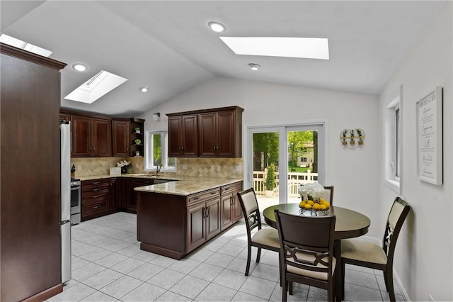 23 Watercress Ct, Coventry, RI 02816 - kitchen featuring a skylight, vaulted ceiling, backsplash, a peninsula, and dark brown cabinetry