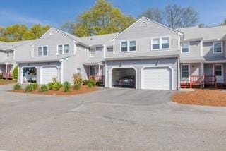 view of property featuring an attached garage and asphalt driveway