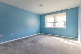 unfurnished room with carpet flooring and baseboards