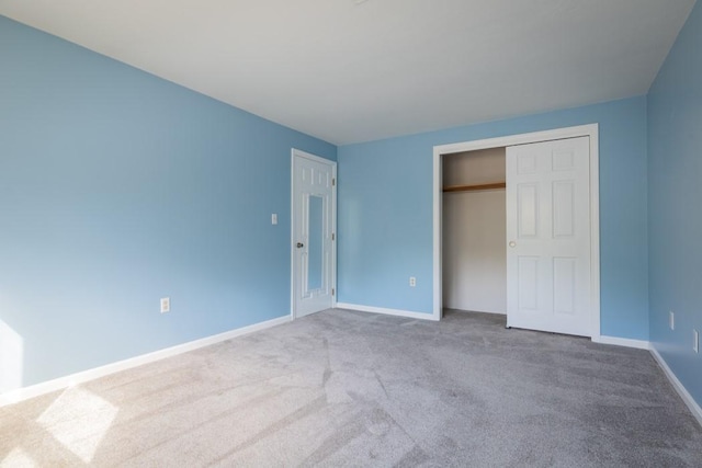 unfurnished bedroom with carpet floors, baseboards, and a closet