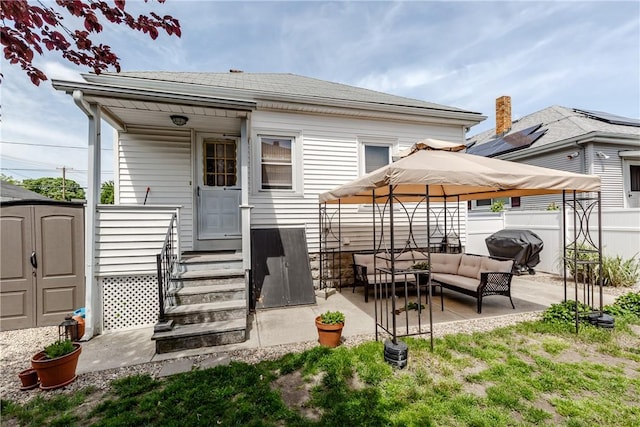 94 Bentley St, East Providence, RI 02914 - back of property with an outdoor hangout area, a storage shed, fence, entry steps, and a patio area