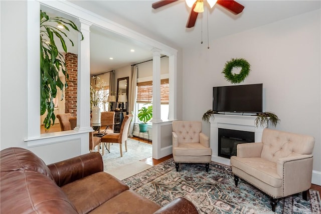 94 Bentley St, East Providence, RI 02914 - living area with decorative columns, ceiling fan, wood finished floors, a glass covered fireplace, and recessed lighting