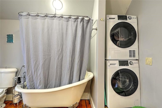 washroom featuring stacked washer / dryer and wood finished floors