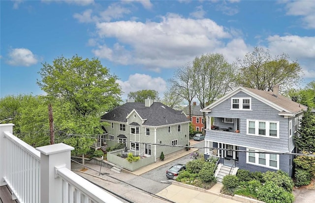 rear view of property with a balcony and a chimney