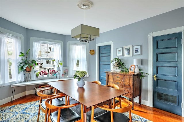 dining area with wood finished floors, baseboards, and a chandelier
