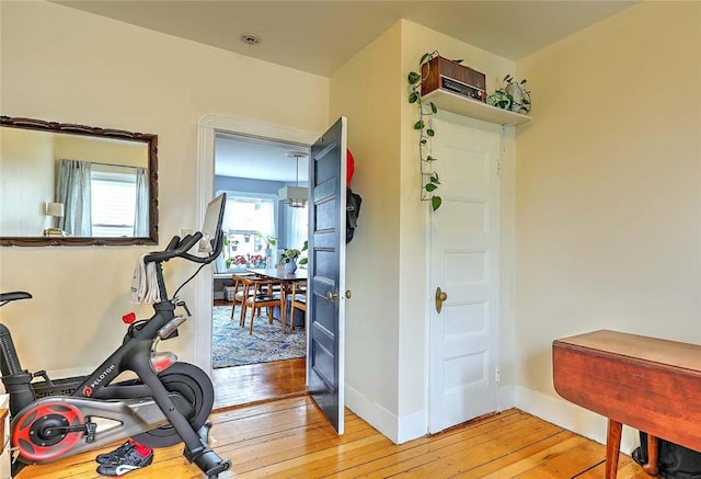 exercise area with light wood-style floors and baseboards