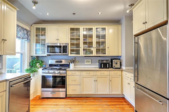 kitchen with stainless steel appliances, light wood-style floors, cream cabinetry, and recessed lighting