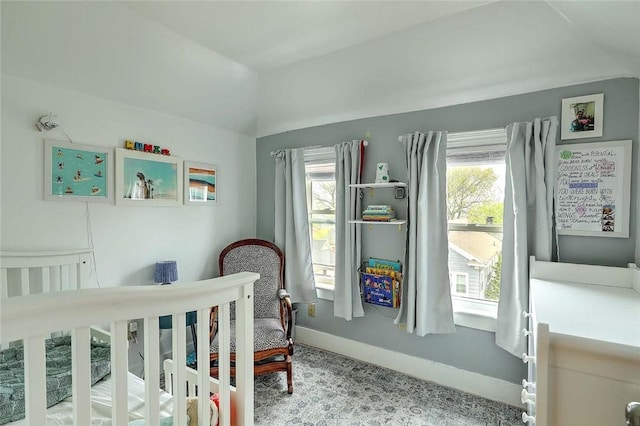 bedroom featuring lofted ceiling and baseboards