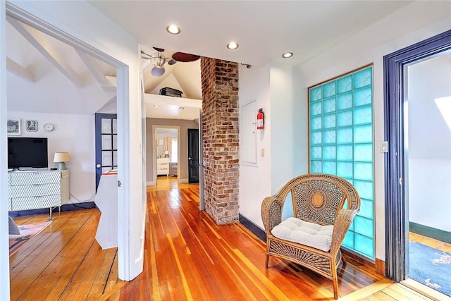 hallway featuring lofted ceiling, light wood-style flooring, and recessed lighting
