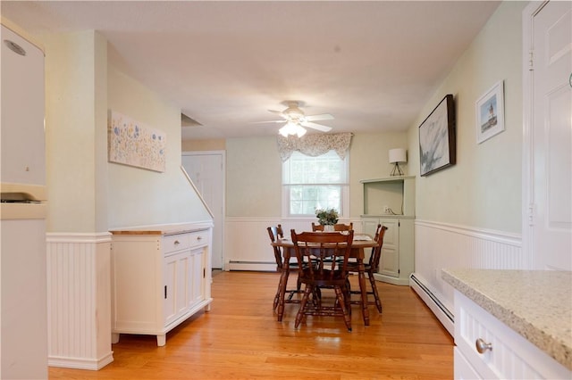 62 Vallette St, Cranston, RI 02920 - dining area with a baseboard heating unit, wainscoting, a ceiling fan, and light wood finished floors