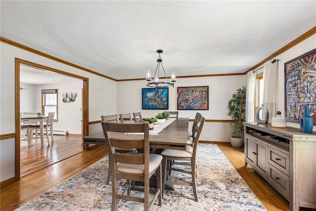 101 Nancy Ln, Burrillville, RI 02830 - dining area with a chandelier, hardwood / wood-style floors, crown molding, and baseboards