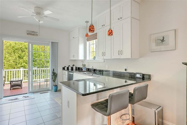 kitchen featuring healthy amount of natural light, white cabinetry, a ceiling fan, and light tile patterned flooring
