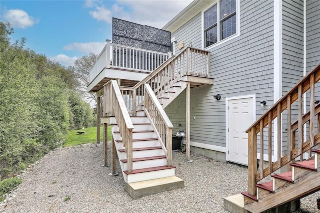 view of side of home featuring stairway and a wooden deck