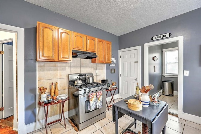 10 Westcott Ave Unit 1, Boston, MA 02124 - kitchen featuring gas range, under cabinet range hood, tasteful backsplash, light tile patterned floors, and a textured ceiling