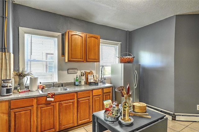 10 Westcott Ave Unit 1, Boston, MA 02124 - kitchen featuring a sink, freestanding refrigerator, light tile patterned floors, a textured ceiling, and brown cabinets