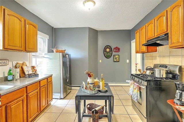 10 Westcott Ave Unit 1, Boston, MA 02124 - kitchen with appliances with stainless steel finishes, under cabinet range hood, a textured ceiling, tasteful backsplash, and brown cabinets