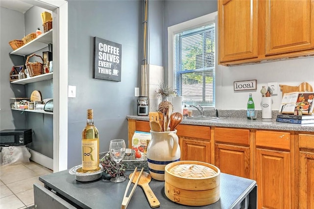 10 Westcott Ave Unit 1, Boston, MA 02124 - kitchen featuring a sink, light tile patterned floors, a wood stove, and brown cabinetry