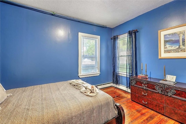 10 Westcott Ave Unit 1, Boston, MA 02124 - bedroom featuring hardwood / wood-style flooring, a textured ceiling, and a baseboard heating unit