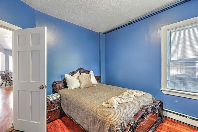 10 Westcott Ave Unit 1, Boston, MA 02124 - bedroom with wood finished floors, a baseboard heating unit, multiple windows, a textured ceiling, and vaulted ceiling