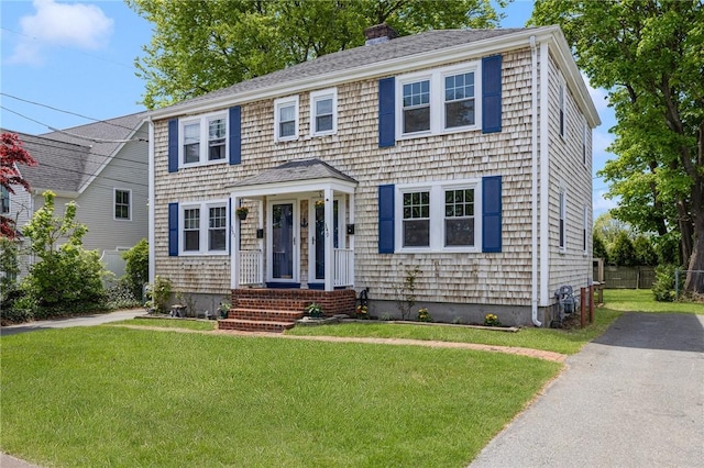 colonial house with a front yard and a chimney