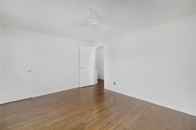 spare room featuring wood finished floors, baseboards, and ceiling fan