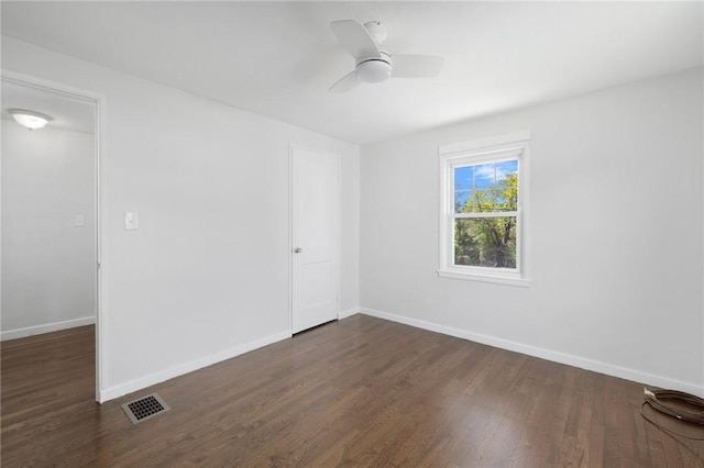 spare room featuring dark wood-style floors, baseboards, and ceiling fan