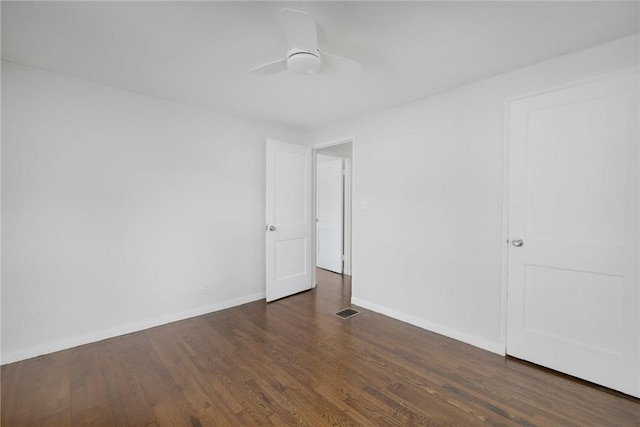 spare room with wood finished floors, baseboards, and a ceiling fan