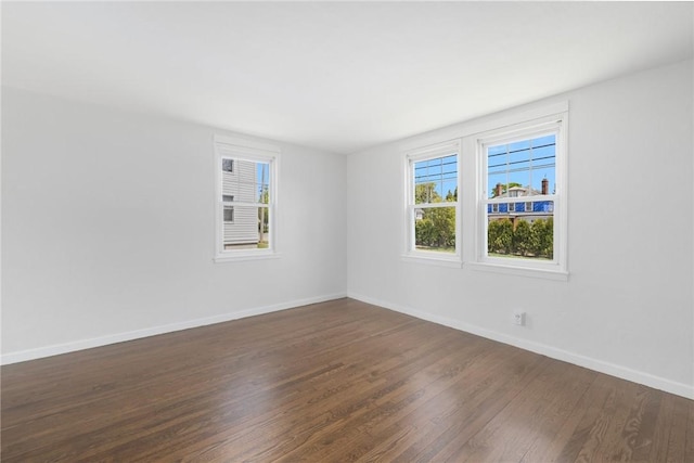 empty room with dark wood-style floors and baseboards