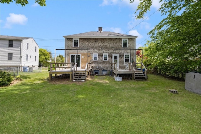 rear view of property featuring a deck and a chimney