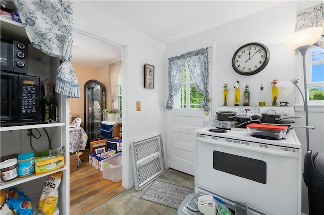 kitchen with electric range, black microwave, and light countertops
