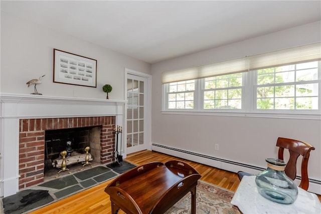 103 Carrs Pond Rd, West Greenwich, RI 02817 - living room with baseboard heating, wood finished floors, and a brick fireplace