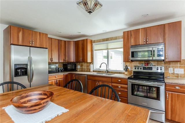 103 Carrs Pond Rd, West Greenwich, RI 02817 - kitchen featuring appliances with stainless steel finishes, a sink, and brown cabinetry