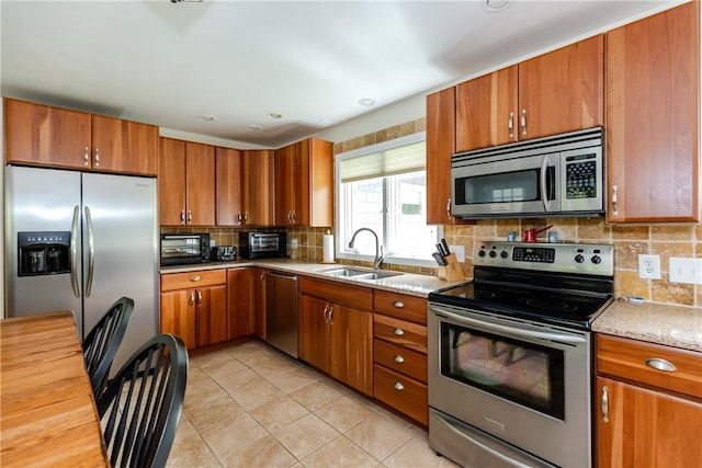103 Carrs Pond Rd, West Greenwich, RI 02817 - kitchen featuring stainless steel appliances, a sink, brown cabinets, and tasteful backsplash