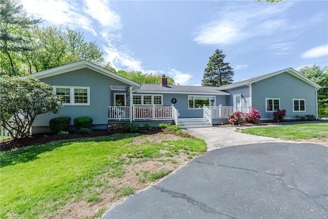 103 Carrs Pond Rd, West Greenwich, RI 02817 - ranch-style house with a front lawn, a chimney, a wooden deck, and asphalt driveway
