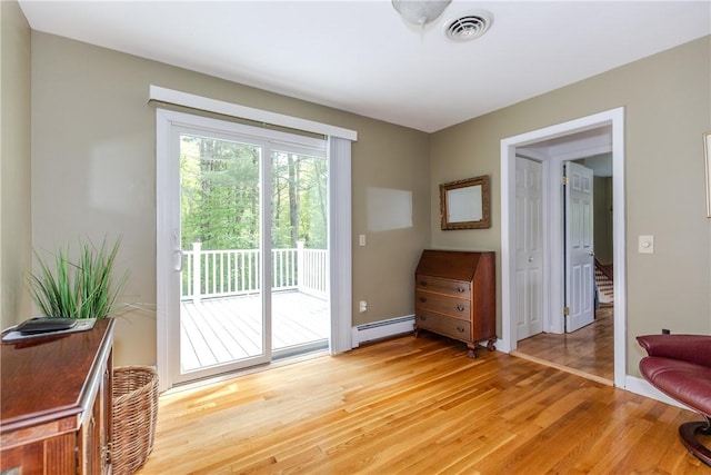 103 Carrs Pond Rd, West Greenwich, RI 02817 - doorway with baseboard heating, light wood-style flooring, baseboards, and stairs