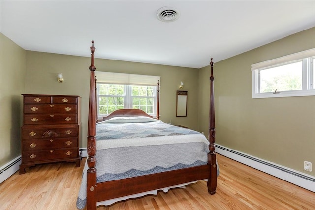 103 Carrs Pond Rd, West Greenwich, RI 02817 - bedroom featuring baseboard heating, multiple windows, and light wood-style flooring