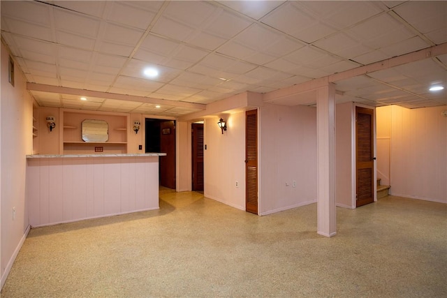 unfurnished living room with a paneled ceiling, stairs, baseboards, and built in shelves