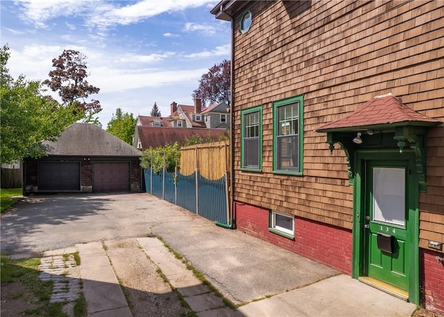 view of home's exterior featuring fence, an outbuilding, and a garage
