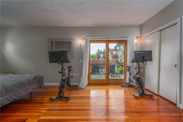 bedroom with access to exterior and wood finished floors