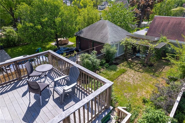 wooden terrace with a garage, a yard, and outdoor dining area