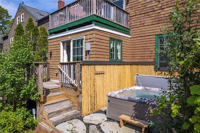 view of home's exterior featuring a hot tub and a balcony