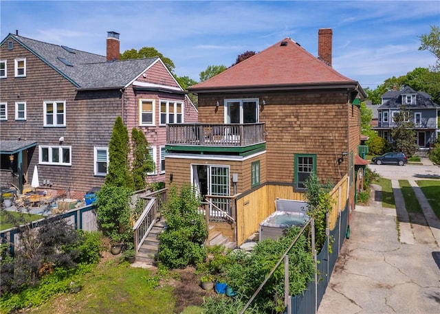 back of property featuring a chimney and roof with shingles