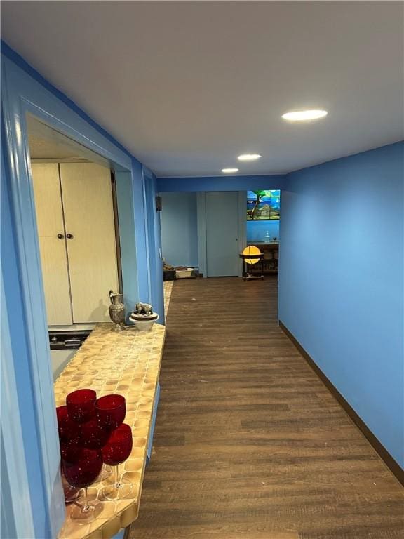 hall with dark wood-type flooring and baseboards